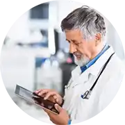 A man in a lab coat is using a tablet.