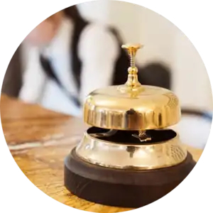 An IT support company's gold bell sits on top of a wooden table.