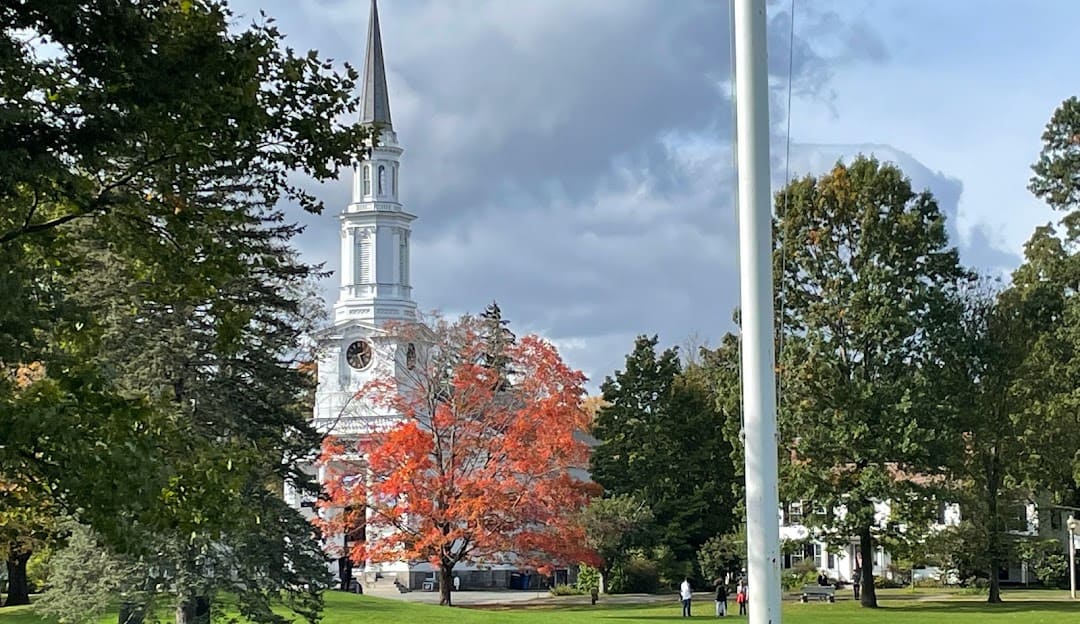 A white church with a steeple in the background.