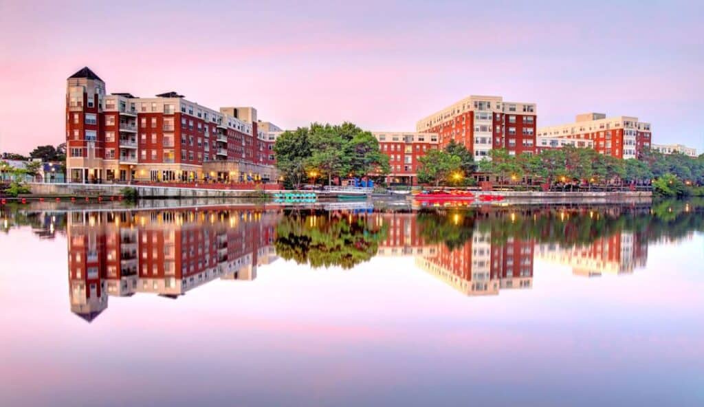 A calm evening with modern residential buildings reflected in a still water body, illuminated by the nearby managed IT services Waltham.