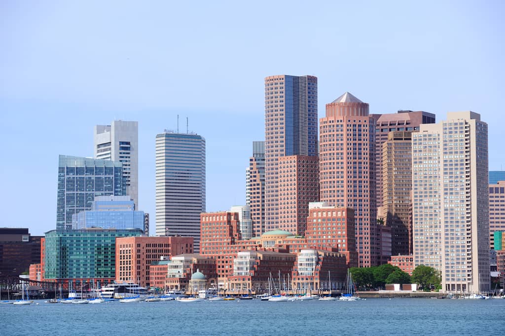 Boston skyline viewed from the harbor, featuring modern skyscrapers and waterfront buildings on a clear day in our service area.