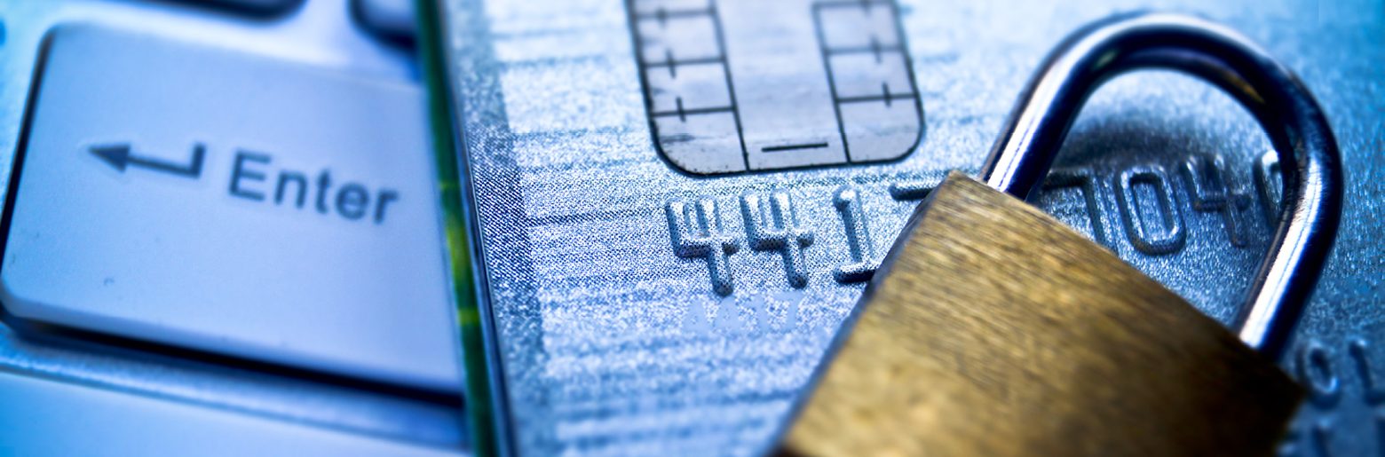 Close-up of a credit card with a chip beside a computer keyboard's Enter key.