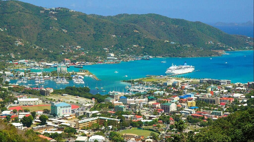 A coastal city with colorful buildings, marinas, and cruise ships docked in a bright blue bay, surrounded by green hills under a clear sky—an ideal hub for Managed IT Services in the British Virgin Islands.