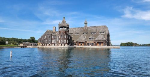 A large, historic stone building with turrets located on the waterfront under a clear blue sky offers managed IT services in Alexandria.