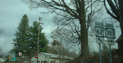 Intersection with road signs indicating routes 62 north and 353 south on a cloudy day with patches of snow on the ground, near the area providing managed IT services in Dayton.