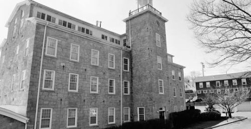 Black and white photo of a historic multi-story building with a tower, managed IT service in Dedham.