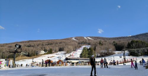 Skiers at the base of a snowy mountain, admiring the ski slopes under a clear blue sky, discussed their plans to enhance their experience with managed IT services in Durham.