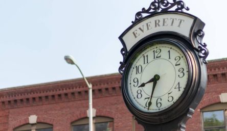 A clock on a pole stands in the town square. A clock on a pole stands in the town square.