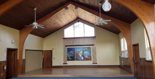 Spacious room with vaulted wooden ceiling, ceiling fans, and a large picture window, managed it service georgetown.