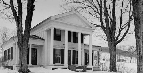 Historic white building with columns in a snowy landscape, reminiscent of the elegance found in managed IT services Maine.