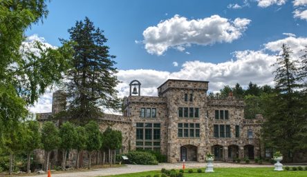 A stone building with a bell tower surrounded by trees near Managed IT Services in Mansfield.