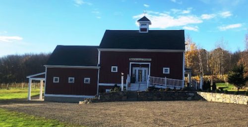 Red barn with a managed it services cupola under a clear sky.