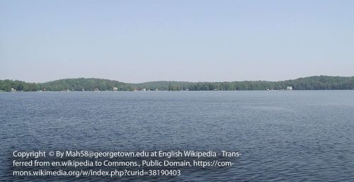 A wide, calm lake with a forested treeline in the distance under a clear sky evokes tranquility, much like the seamless support of managed IT services in Stratford. (Photo by Mah58/CC BY-SA 3.0 via Wikimedia Commons).