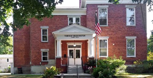 Brick building with white columns and steps, labeled "managed IT services Washington," with an American flag out front.